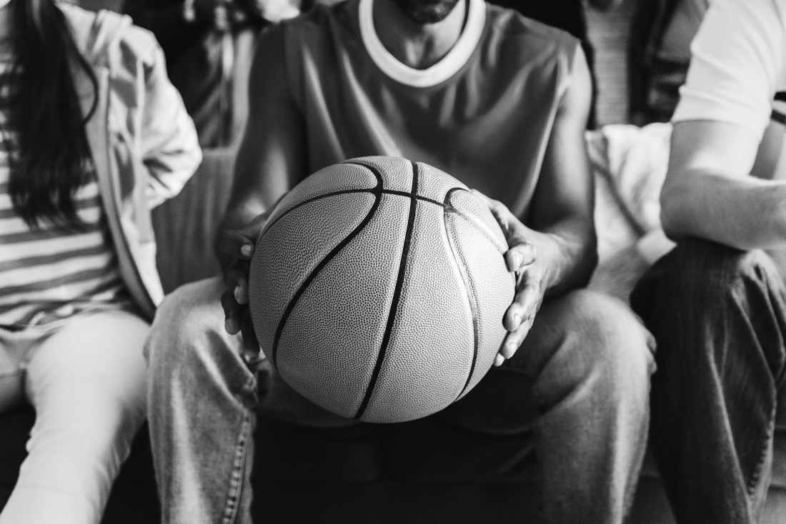 grayscale photography of person holding basketball